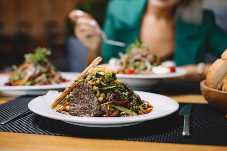 side view of beef meat salad with vegetables corns and lemon juice in a plate